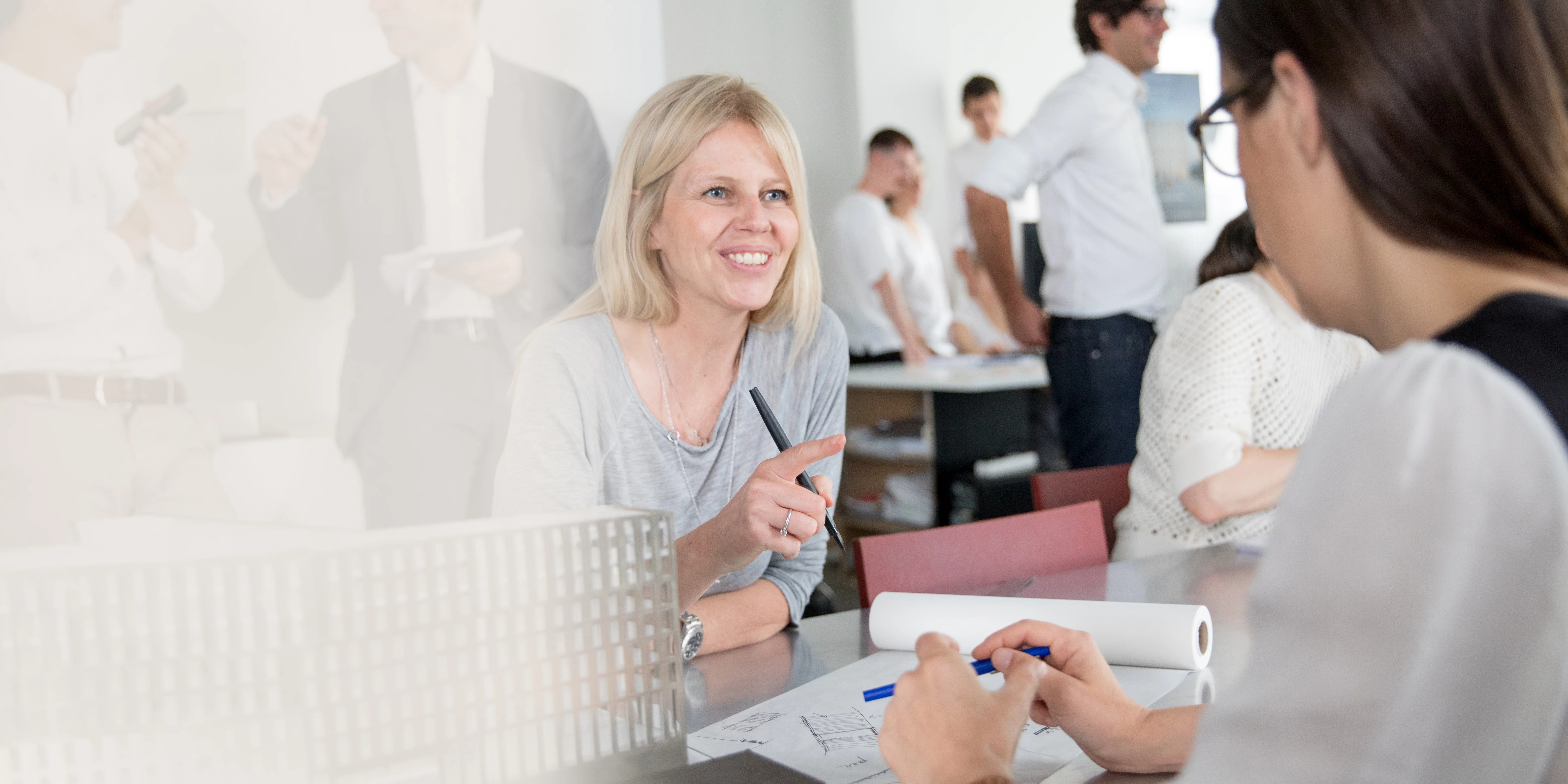 Geschichten erzählen Architektinnen unterhalten sich freundlich im Büro über Architekturpläne und Modelle