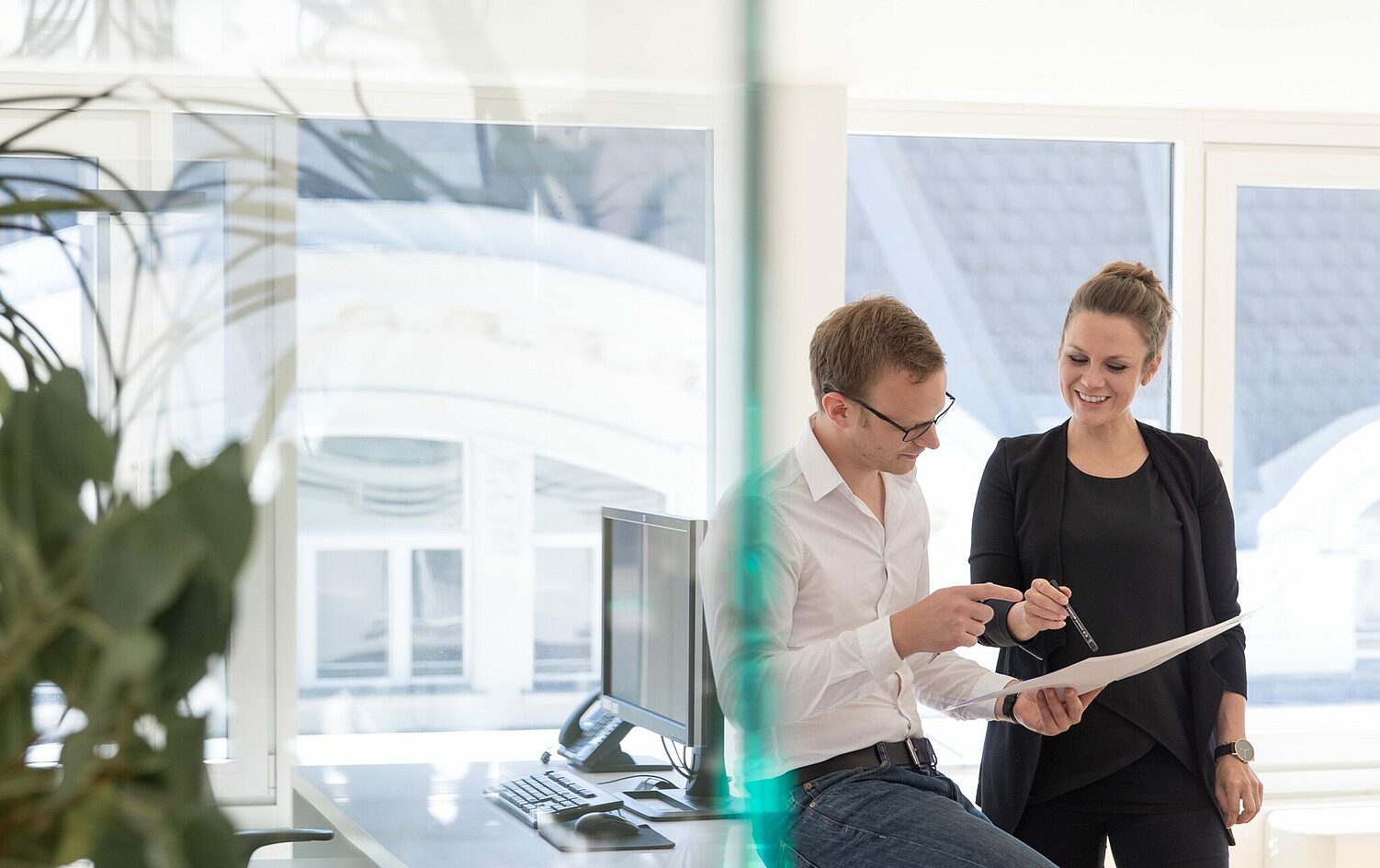 Architekten besprechen gemeinsam ein Dokument am Fensterplatz.