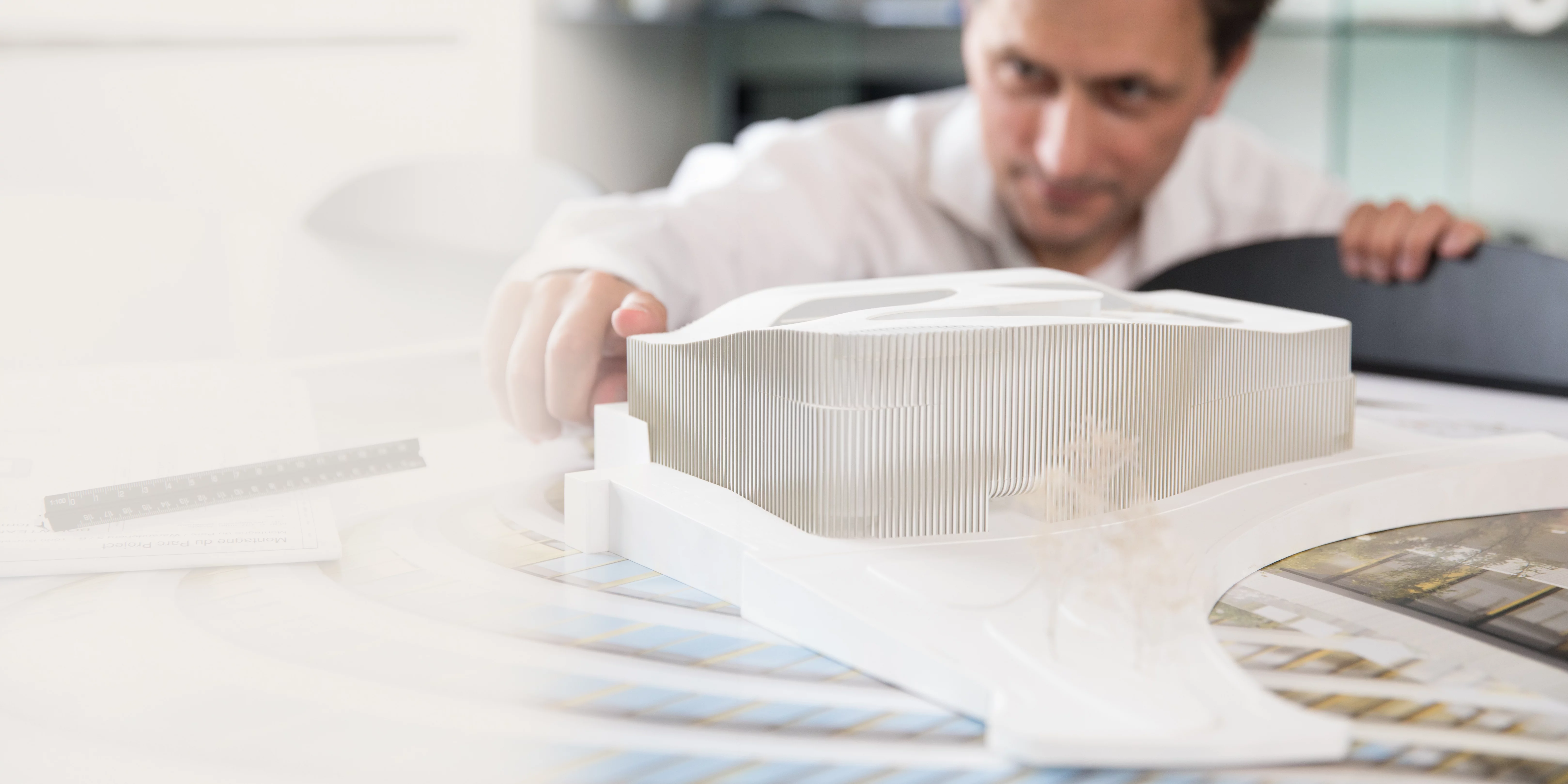 Making statements An architect works with concentration on a detailed architectural model at their desk