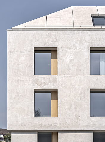 Auszeichnung Moderne, helle Gebäudefassade mit klarer Fensterstruktur und leicht geneigtem Dach