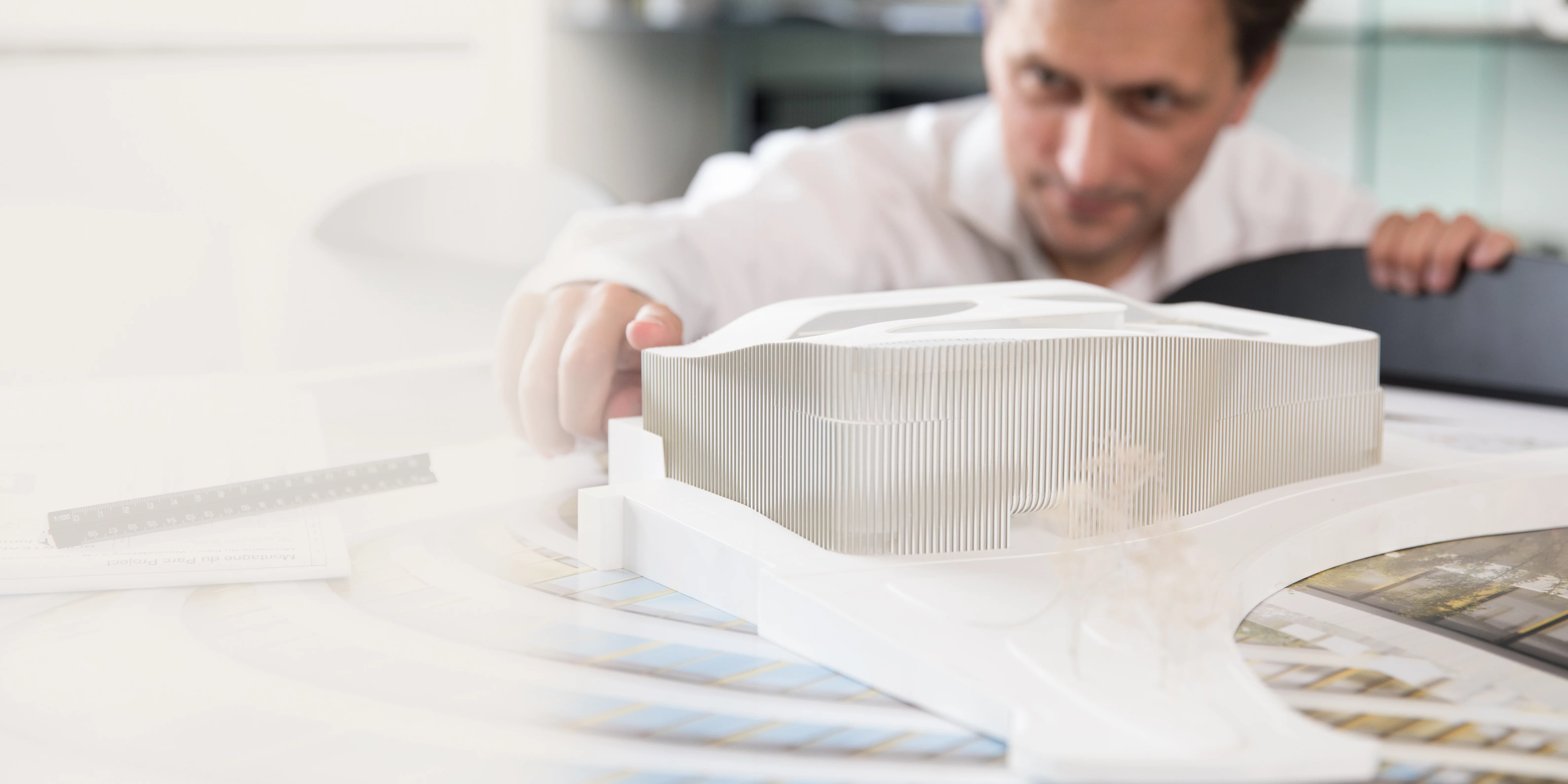 Statements setzen Architekt arbeitet konzentriert an einem detaillierten Architekturmodell am Schreibtisch